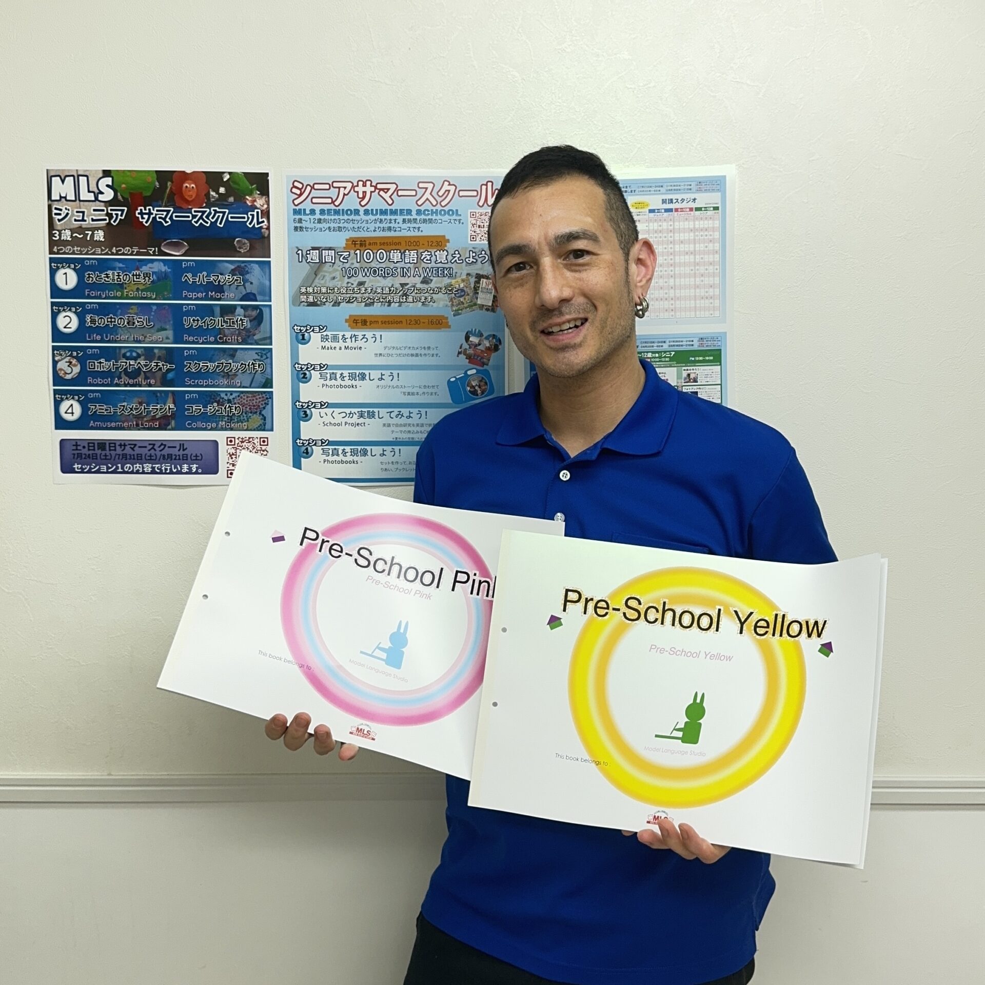 Teacher showcasing Pre-School Pink and Yellow English textbooks